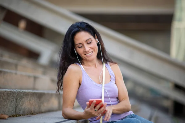 Счастливая Женщина Слушает Музыку Помощью Мобильного Телефона Наушников Расслабляясь Ступеньках — стоковое фото