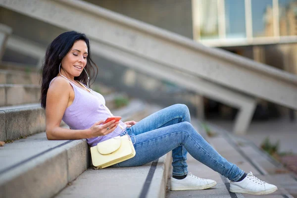 Beautiful Woman Relaxing Staircase While Listening Music Using Mobile Phone — Stock Photo, Image
