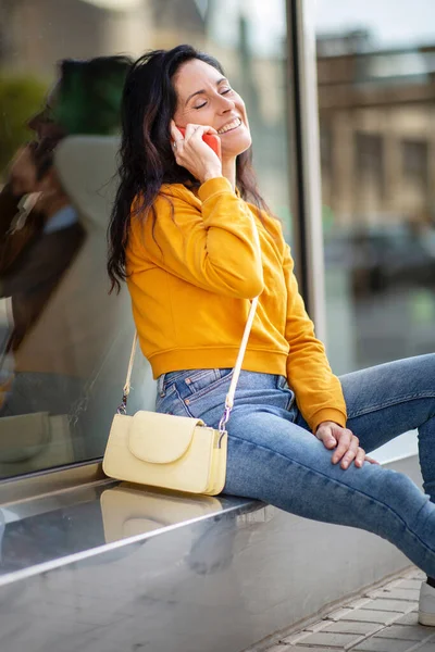 Relaxed Cheerful Caucasian Woman Talking Mobile Phone While Sitting Outdoors — Stock Photo, Image