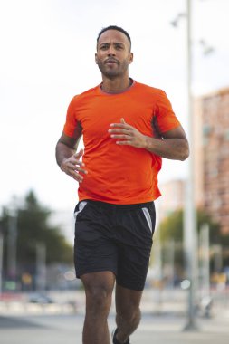 Spor giyim sektöründe erkek sporcu şehir dışında koşuyor.