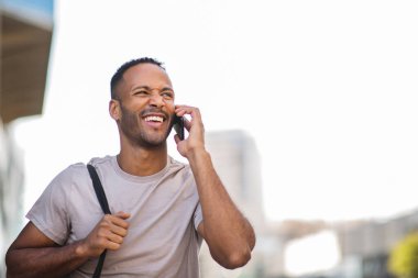 Cep telefonuyla konuşurken yüzünü buruşturan Afrikalı Amerikalı bir adam.