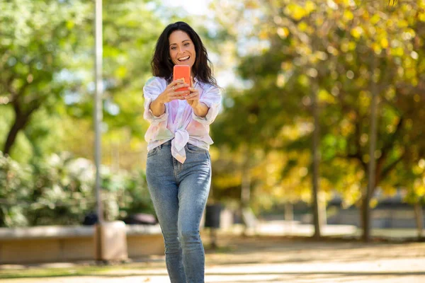 Smiling Mature Woman Taking Selfie Using Mobile Phone While Walking — Stock Photo, Image