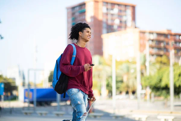 Afroamerikansk Man Med Ryggsäck Och Rullande Resväska Väntar Utomhus Stadens — Stockfoto