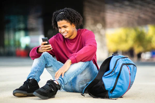 Feliz Hombre Afroamericano Mensajería Usando Teléfono Inteligente Mientras Está Sentado — Foto de Stock