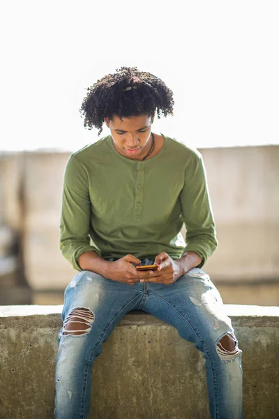 Afrikansk Amerikansk Man Meddelande Med Hjälp Mobiltelefon Medan Sitter Utomhus — Stockfoto