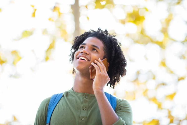 Wesoły Afrykański Amerykanin Spoglądający Górę Podczas Rozmowy Przez Telefon Komórkowy — Zdjęcie stockowe