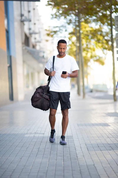 Muž Nesoucí Sportovní Tašku Při Použití Mobilního Telefonu Venku Ulici — Stock fotografie