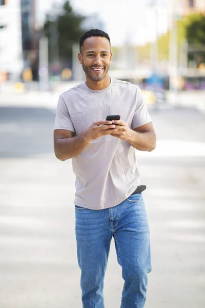 市内の屋外で携帯電話を使用して陽気なアフリカ系アメリカ人の男 — ストック写真