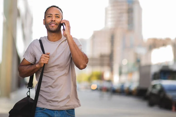 Afričan Američan Mluví Mobilním Telefonu Při Nošení Tašky Venku Městě — Stock fotografie