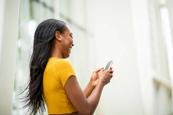 Χαρούμενη Αφρικάνικη Αμερικανική Γυναίκα Μηνυμάτων Κειμένου Χρησιμοποιώντας Κινητό Τηλέφωνο — Φωτογραφία Αρχείου