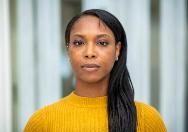 都市の屋外で長い髪を持つ深刻な黒人女性の肖像 — ストック写真