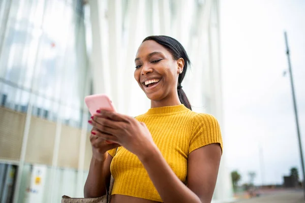 Afrikansk Amerikansk Kvinna Skrattar Medan Meddelanden Med Mobiltelefon Utomhus Staden — Stockfoto