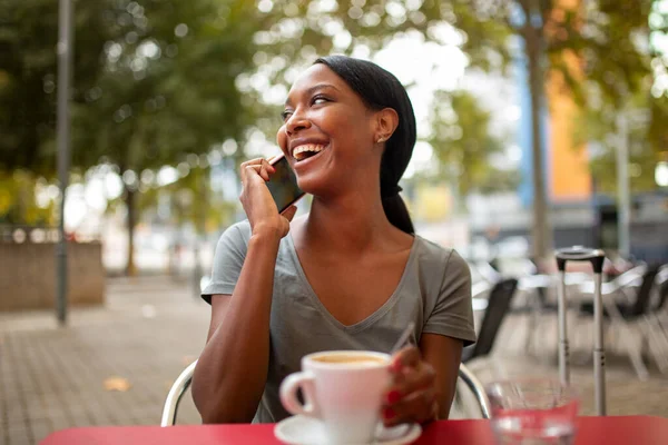 Alegre Mujer Afroamericana Hablando Por Teléfono Mientras Bebe Café Cafetería —  Fotos de Stock
