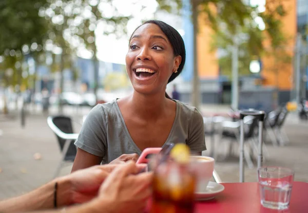 Веселая Африканская Американка Сидя Своим Другом Кафе Тротуаре Пользуется Мобильным — стоковое фото