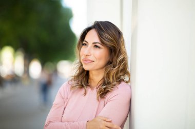 Duvara yaslanıp düşünen genç bir kadının portresi. 