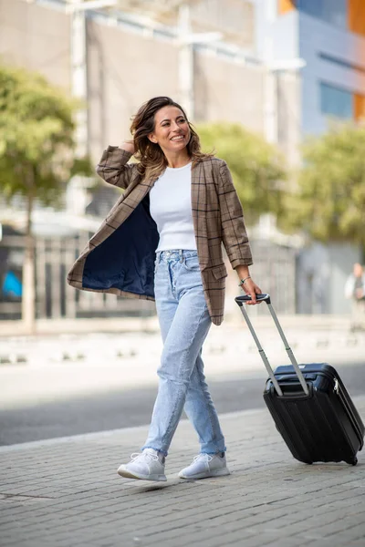Şehirde Bavulu Çeken Mutlu Genç Bir Kadının Vücut Portresi — Stok fotoğraf