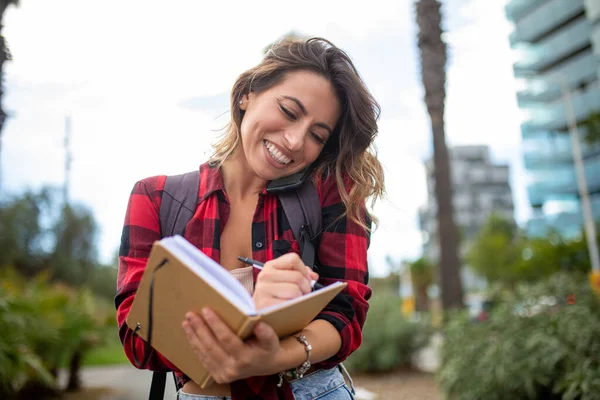 Retrato Mulher Feliz Tomando Notas Livro Enquanto Uma Chamada Com — Fotografia de Stock