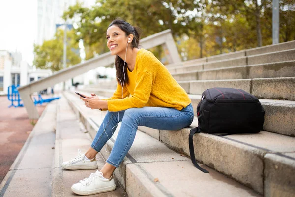 Портрет Счастливой Молодой Женщины Сидящей Мобильным Телефоном Слушающей Музыку Наушниками — стоковое фото