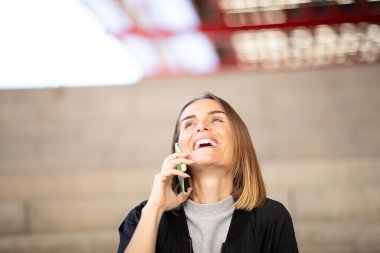 Cep telefonuyla konuşurken gülen kadın portresi 