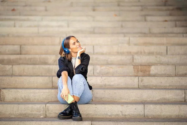 Potret Wanita Yang Duduk Tangga Mendengarkan Musik Dengan Telepon Pintar — Stok Foto