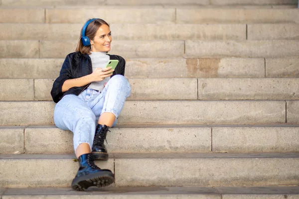 Портрет Улыбающейся Женщины Отдыхающей Лестнице Слушающей Музыку Мобильного Телефона Наушников — стоковое фото
