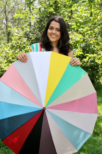 Belle jeune fille posant sur la nature avec parapluie de couleur — Photo