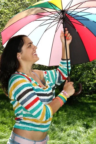 Beautiful young girl posing on nature with color umbrella — Stock Photo, Image