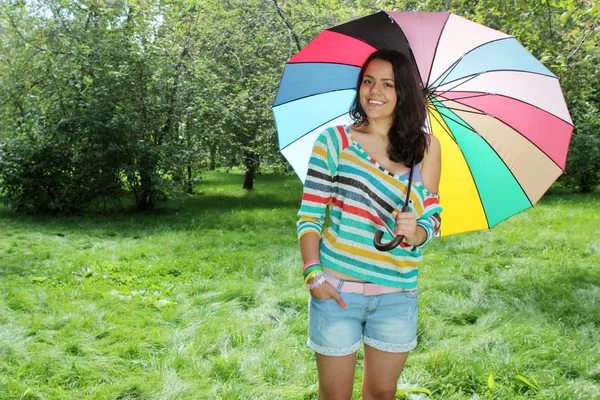 Красива молода дівчина позує на природі з кольоровою парасолькою — стокове фото