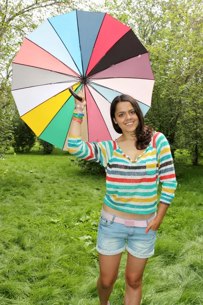 Belle jeune fille posant sur la nature avec parapluie de couleur — Photo