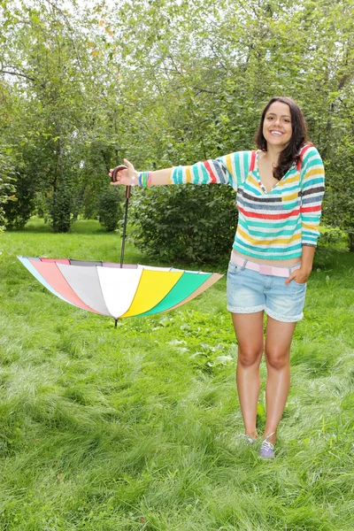 Vacker ung flicka poserar på naturen med färg paraply — Stockfoto