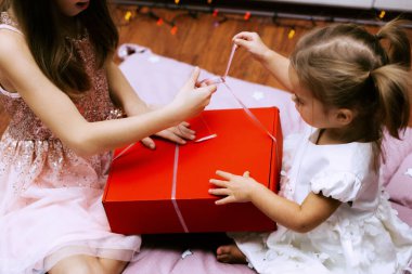 Çocukların elleri hediyelerle dolu bir kutuyu açar