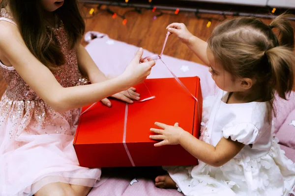 Çocukların elleri hediyelerle dolu bir kutuyu açar