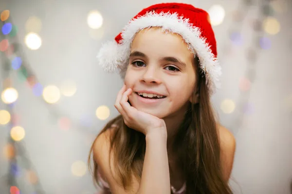 Noel Baba şapkalı şirin bir kızın portresi. Mutlu Noeller.