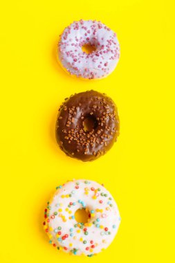 Şekerleme pişirme malzemeleri. Sarı arka planda üç farklı renkte çörek..