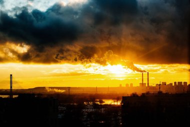 Endüstriyel fabrika güneş batarken duman emisyonlarıyla gezegeni kirletiyor
