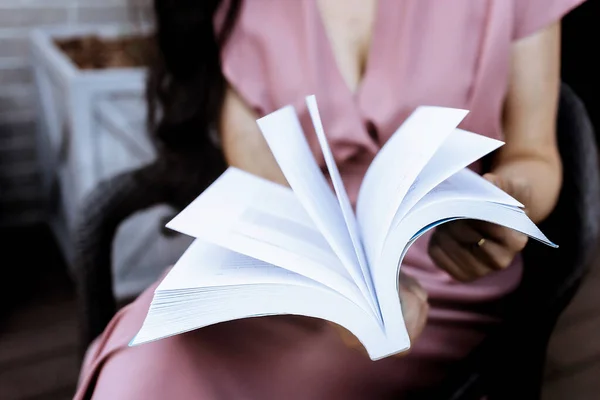 Bir dekolte elbiseli genç bir kız oturur ve bir kitabı karıştırır. Kadın kitap okuyor. Öğrenme kavramı, edebiyat aşkı. Yüzü olmayan resim, sayfaları karıştıran eller.