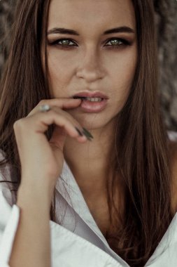 Stüdyoda gösterişli makyajlı güzel bir moda kadınının yakın plan portresi. Yeşil elbiseli çekici bir kadının portresi. Dumanlı göz makyajı. Güzel bir kadın. Yüzü patlamış.