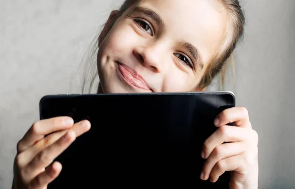 Çevrimiçi öğrenme. Evde ders çalış. Güzel gülüşü olan tatlı bir bebek. Tablet tutan zeki ve şık bir kızın portresi. Boşluğu kopyala.