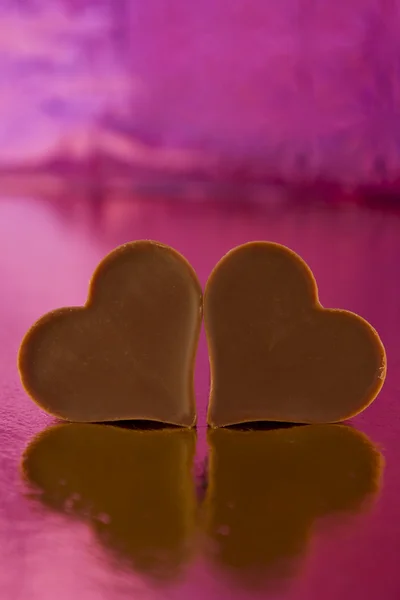 Chocolate hearts on a pink background — Stock Photo, Image