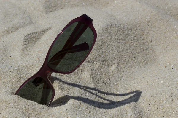 Close up of a sunglasses on the sand — Stock Photo, Image