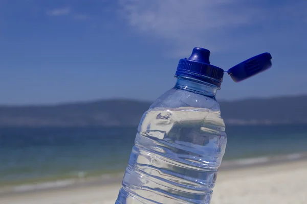 Abra la botella de agua en la playa — Foto de Stock