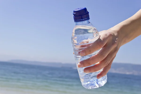 Mano de la mujer con una botella de agua — Foto de Stock
