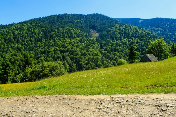 House and road in mountains — Stock Photo, Image