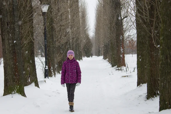 Girl in snowing alley — Stock Photo, Image