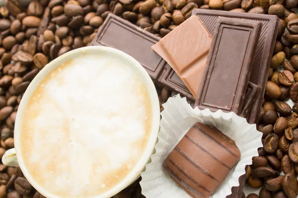 Schokolade auf Kaffeebohnen Hintergrund — Stockfoto
