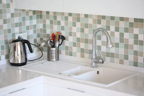 La moderna cucina bianca in stile high-tech con top bianco e lavabo bianco. frammento di interno — Foto Stock