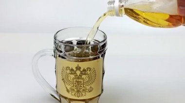 Taze, soğuk, hafif biralar, Rusya Federasyonu 'nun arması olan bir bardağa dökülüyor. Saniyede 60 kare.
