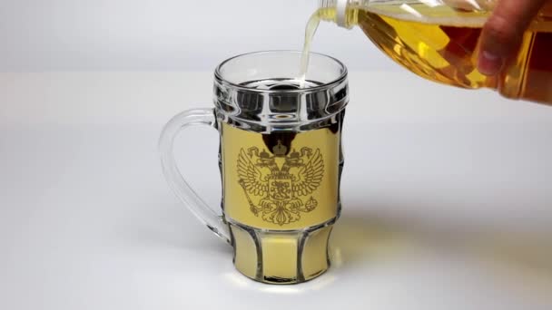 Fresh, cold, light beer is poured into a mug with a picture of the coat of arms of the Russian Federation. 25 frames per second.