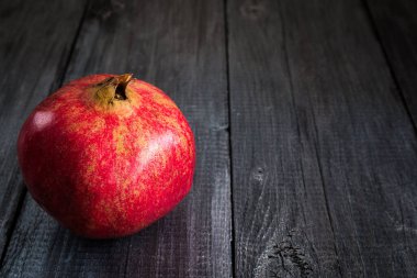 Koyu ahşap arka planda nar meyvesi. Metin için bir yer var..