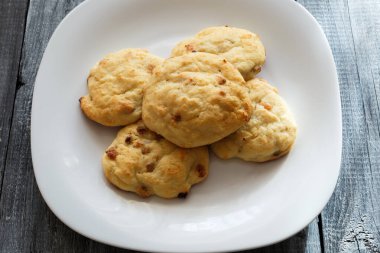 Kuru üzümlü süzme peynirden tatlı. Ahşap arka planda beyaz bir tabakta fırında pişirilmiş süzme peynirli krep..